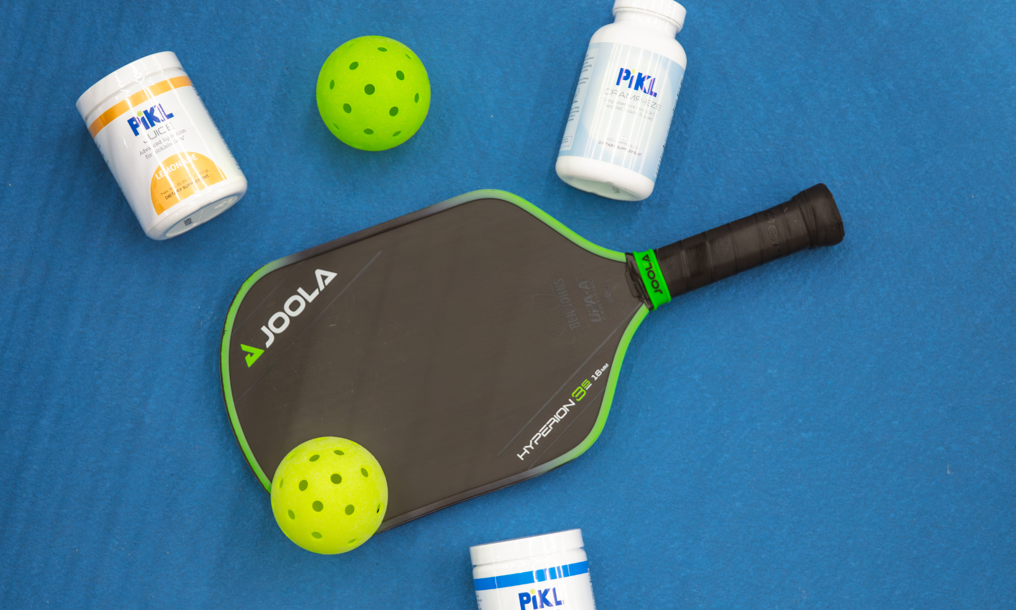 Joola pickleball paddle with a green ball on a blue background
